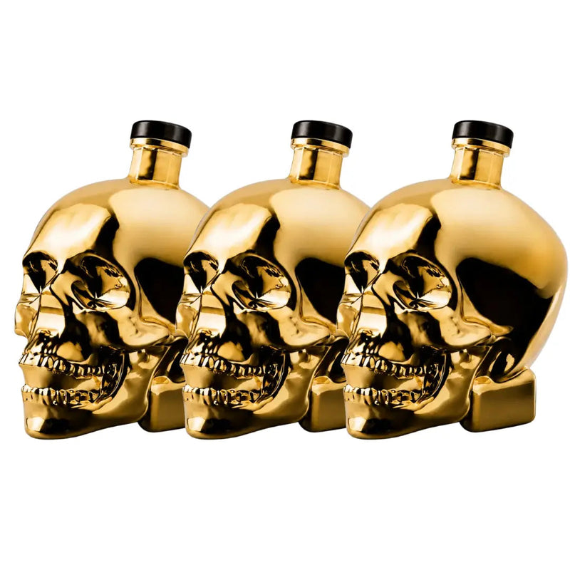 Load image into Gallery viewer, Three black-capped gold skull bottles of Crystal Head Vodka Gold Edition (Pre-Order) from Crystal Head Vodka are arranged in a row against a white background—an impressive showcase of this premium Canadian vodka.
