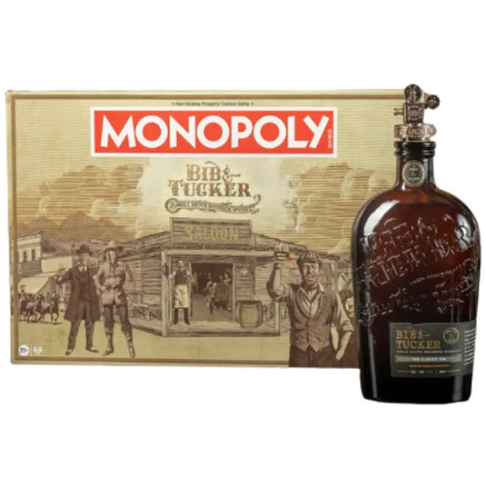 The Bib & Tucker MONOPOLY Collector’s Edition Bourbon & Board Game Bundle box featuring a Western saloon scene next to a bottle of Bib & Tucker Bourbon with a metal game piece stopper.