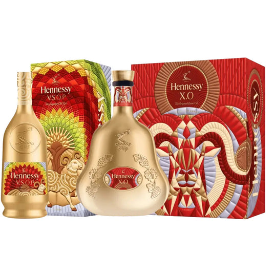 Two gold Hennessy Lunar New Year 2027 Year of the Goat V.S.O.P & X.O Cognac bottles displayed in front of their respective decorative boxes featuring illustrations of goats.