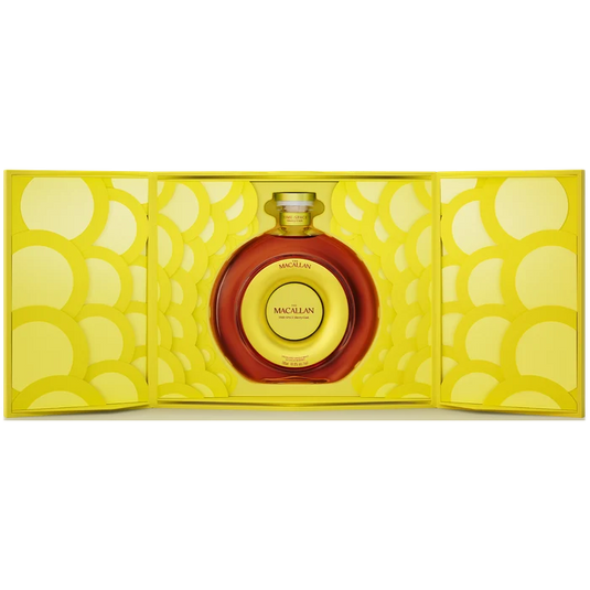 A round bottle of The Macallan TIME : SPACE Sherry Cask Single Malt Scotch Whisky sits centered in an open, bright yellow box with a circular pattern, nestled within the decorative interior.