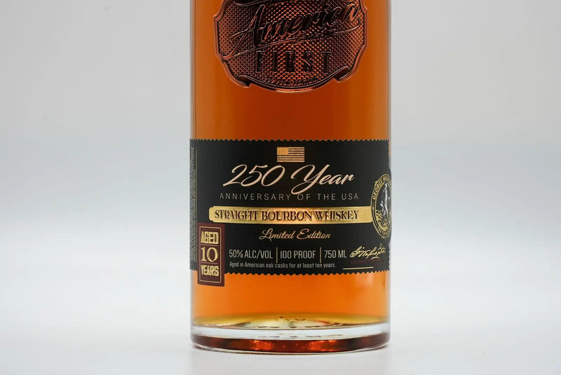 Load image into Gallery viewer, A close-up of a whiskey bottle label reads “America First 250 Year Limited Edition Bourbon, Straight Bourbon Whiskey, 10 Years Old, 50% Alc/Vol, 100 Proof, Limited Edition Bourbon, 750 mL.”.
