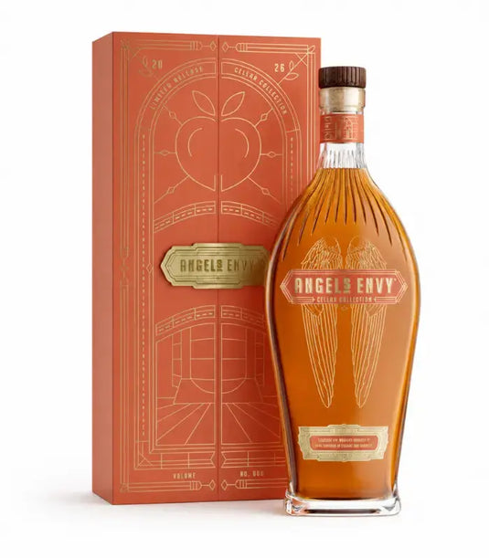 Standing before a vibrant orange and gold decorative box, a bottle of Angel’s Envy Cellar Collection Vol. 6 2026 Peach Brandy & Toasted Oak Finished Rye Whiskey features elegant gold lettering and signature angel wing motifs. This limited release from Angel’s Envy is expertly crafted rye whiskey, uniquely finished in peach brandy and toasted oak casks for a distinctive richness of character.