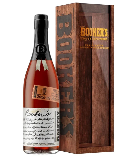 A bottle of Booker’s Batch 2026-02 “Milkshake Batch” Kentucky Straight Bourbon Whiskey by Booker’s, featuring its iconic wax seal and handwritten label, stands beside its wooden display box, which displays the BOOKER’S branding and product details along the side.