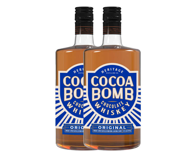 Load image into Gallery viewer, Two bottles of Cocoa Bomb Whiskey - 2 Bottle by Heritage Distilling, featuring blue and white "Cocoa Bomb Chocolate Whiskey Original" labels. The clear bottles reveal the light brown whiskey inside.
