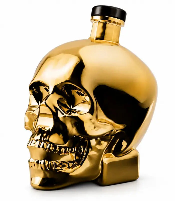 Load image into Gallery viewer, A gleaming gold Crystal Head Vodka Gold Edition (Pre-Order) bottle by Crystal Head Vodka, designed in the shape of a human skull with a black cap and set against a white background, highlights the bold and luxurious look of this premium Canadian vodka.
