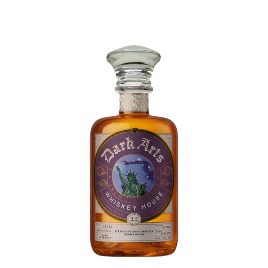 A bottle of America 250 Years of Spirit 5X Blend Bourbon from Dark Arts Whiskey House, featuring a purple ornate label with the Statue of Liberty and crescent moon, and topped with a clear glass stopper.