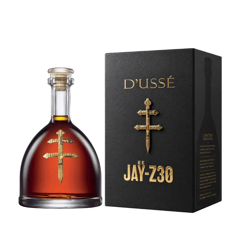 Load image into Gallery viewer, A bottle of D’USSE VSOP Jay-Z30 Limited Edition Cognac (PRE-ORDER) by D’USSÉ is displayed with a gold cross emblem next to a black box featuring gold lettering, reflecting the luxury of this limited-edition French cognac.

