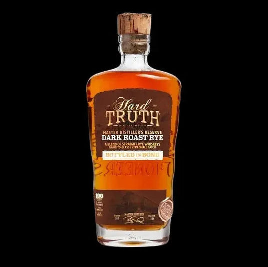 A bottle of Hard Truth Master Distiller’s Reserve Dark Roast Rye Bottled in Bond by Hard Truth, a limited whiskey release, featuring a cork top, dark brown label, and gold accents, set against a black background.