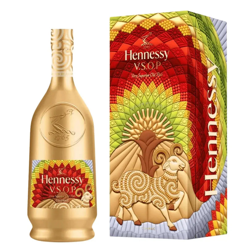 Load image into Gallery viewer, The Hennessy V.S.O.P Year Of The Goat Limited Edition by Raxxy features a striking gold bottle and a vibrant box adorned with mosaic-inspired patterns in red, yellow, and green, along with a stylized ram—a unique collaboration between Hennessy and Raxxy.

