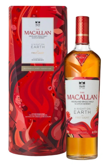A bottle of The Macallan A Night On Earth The First Light Highland Single Malt Scotch Whisky stands beside its vibrant, abstract red and orange cylindrical packaging, highlighting the limited edition presentation from The Macallan.
