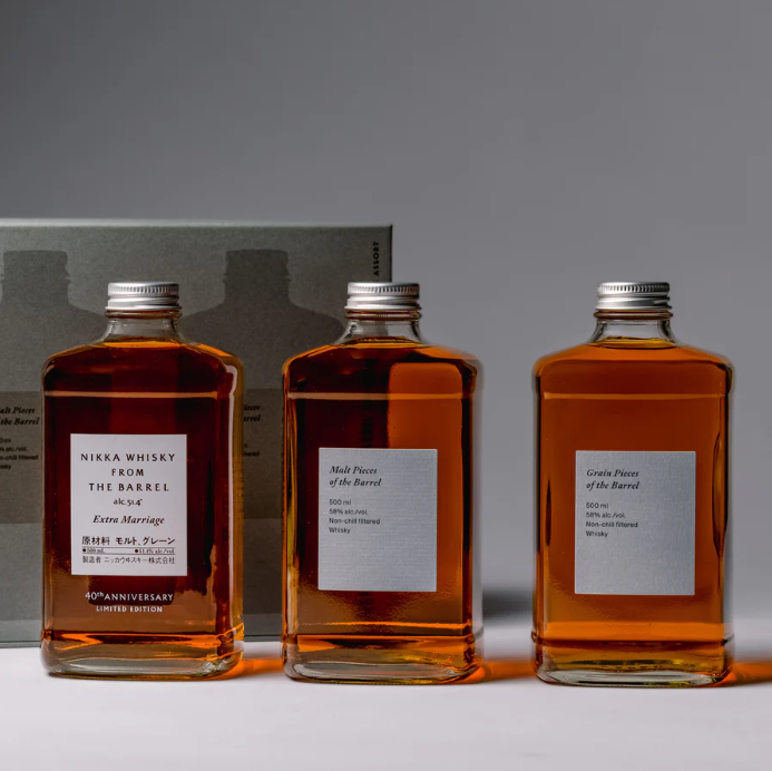 Load image into Gallery viewer, Three rectangular bottles of Nikka whisky—including the 40th Anniversary Limited Edition—stand side by side before a gray box in the Nikka From The Barrel Extra Marriage Gift Set, an eye-catching Japanese collector’s item with glowing amber tones.
