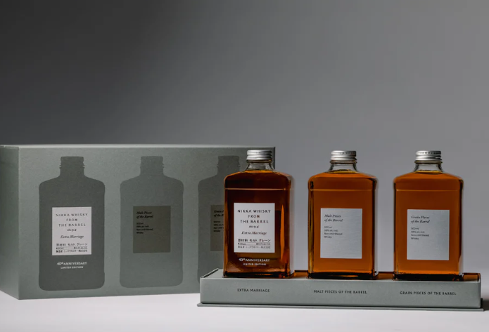 Load image into Gallery viewer, Three rectangular bottles from the Nikka From The Barrel Extra Marriage Gift Set are displayed before a gray gift box with bottle silhouettes and labeled sections, celebrating this limited edition release from Nikka.
