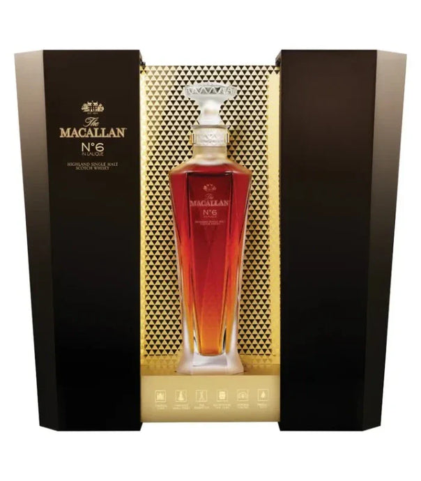A bottle of The Macallan No. 6 Lalique Single Malt Scotch Whiskey by The Macallan, presented in a luxury crystal decanter and displayed in an elegant black and gold box with geometric patterns.