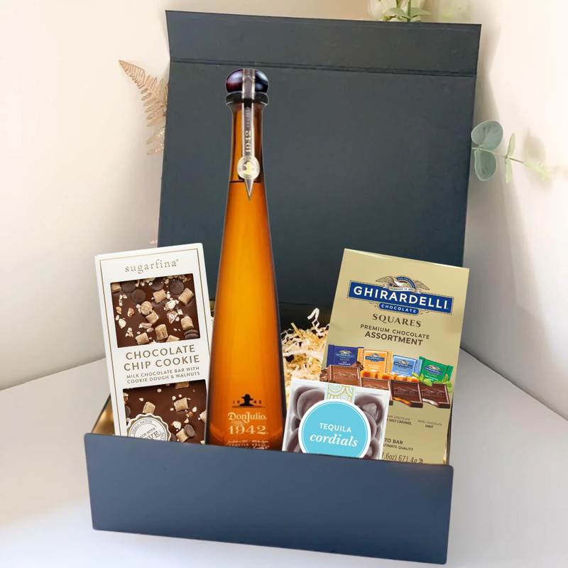 Load image into Gallery viewer, The Premium Tequila Gift Box by Main Street Liquor includes Don Julio 1942, Sugarfina chocolate chip cookie bites, Ghirardelli squares, and tequila cordials, all beautifully arranged on a white surface.
