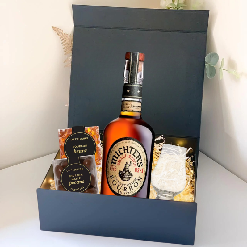 Load image into Gallery viewer, The Premium Bourbon Gift Box by Main Street Liquor includes Michter’s bourbon, a glass with ice, honeycomb snack, bourbon bears, and bourbon pecans—elegantly arranged with decorative straw for the perfect whiskey gift.
