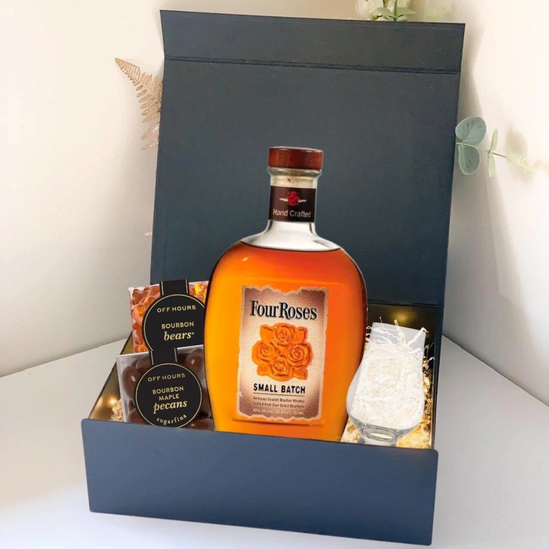 Load image into Gallery viewer, The Premium Bourbon Gift Box by Main Street Liquor includes a Four Roses Small Batch bottle, two small jars of bourbon pecans and bourbon bears, a clear glass, and decorative string lights—all in an elegant black box.
