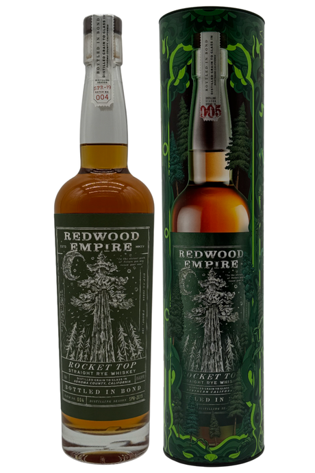 A bottle of Redwood Empire Rocket Top Bottled in Bond Straight Rye Whiskey Batch 004 2025 Release by Redwood Empire Whiskey stands beside its matching green cylinder, both adorned with a redwood tree and forest-inspired Sonoma County design.