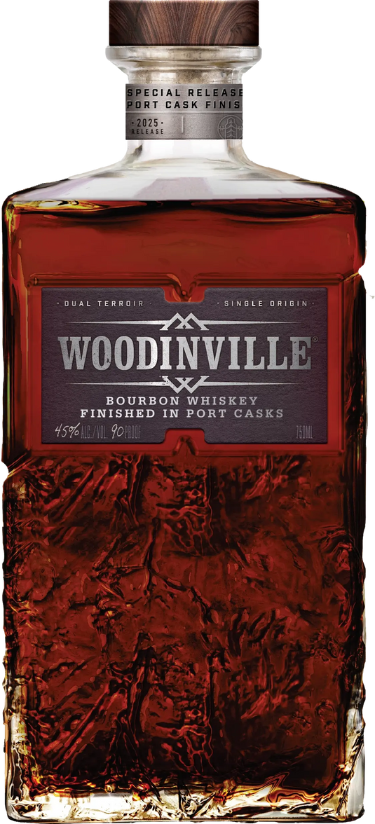 A bottle of Woodinville Port Finished Straight Bourbon, a straight bourbon whiskey from Woodinville, finished in ruby port casks. The label reads Special Release and indicates 45% ALC/VOL (90 PROOF), while the glass features a textured pattern on its lower portion.