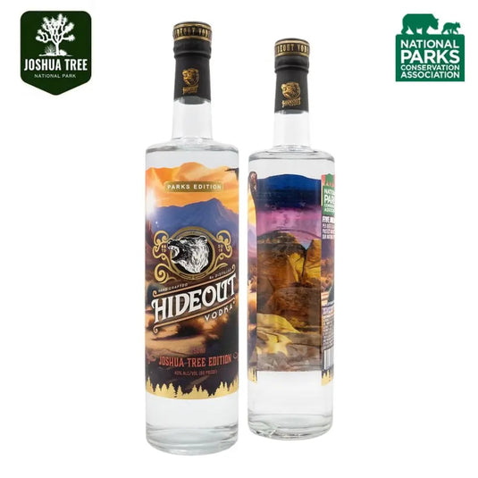 Two bottles of Hideout Vodka Joshua Tree Edition, featuring scenic park imagery on the label. The packaging displays the Joshua Tree National Park and National Parks Conservation Association logos in the corners.