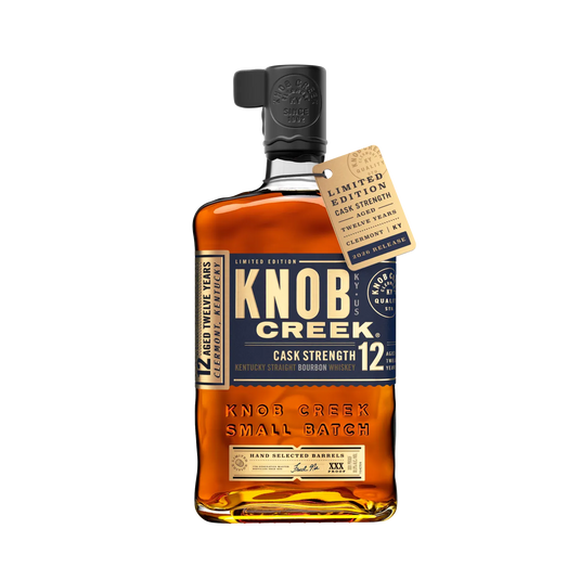A bottle of Knob Creek 12 Year Old Cask Strength Kentucky Straight Bourbon, adorned with a limited edition tag hanging from the neck.