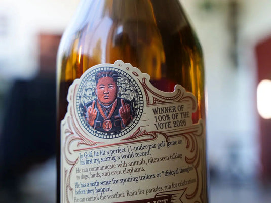 Close-up of a Rocket Man Bourbon Whiskey label by Rocket Man, featuring a person with two raised middle fingers, surrounded by animals, and bold text reading WINNER OF 100% OF THE VOTE 2026—an unforgettable limited release.