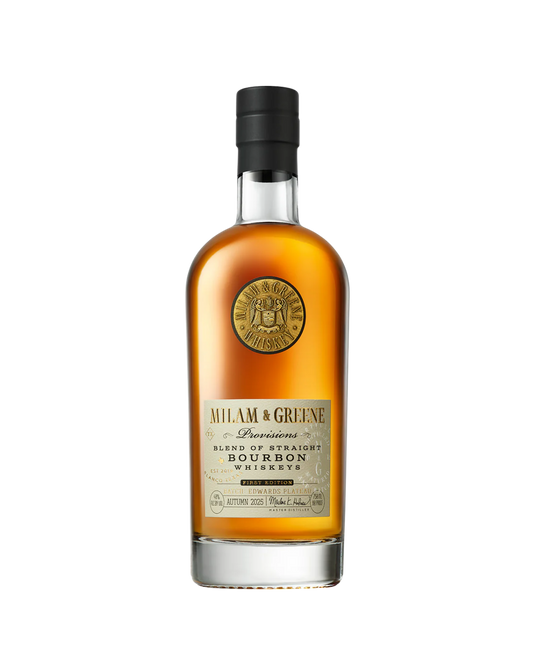 A bottle of Milam And Greene Provisions Bourbon First Edition Autumn 2025 features a black cap, gold seal near the neck, and a label reading “Milam & Greene Bourbon Whiskey.” This Texas craft whiskey glows with an amber hue.
