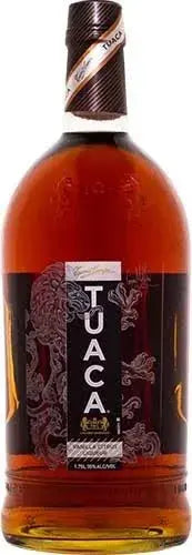 A 1.75L bottle of Tuaca Italian Liqueur features an ornate dragon motif on the label and a gold-and-black neck seal, showcasing the brand’s signature amber-hued vanilla liqueur that is both distinctive and inviting.