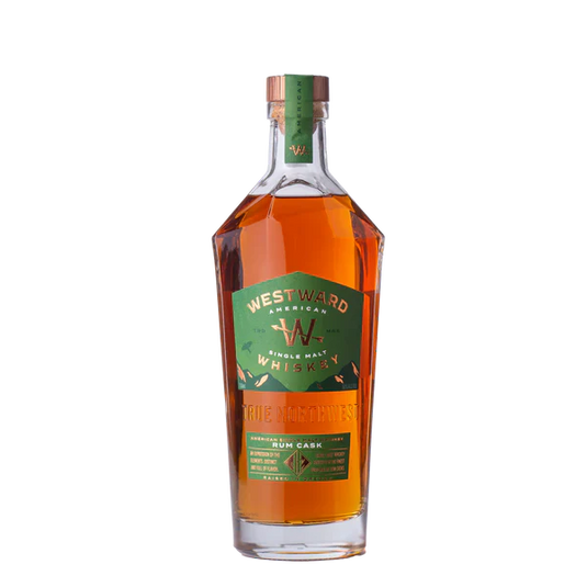 A bottle of Westward American Single Malt Rum Cask by Westward, with a green and gold label, wooden cap, and amber whiskey inside, is shown against a plain white background.